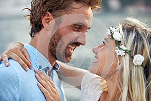 Beautiful bride in white dress enjoys the embrace of her man