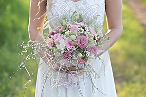 Beautiful bride in white wedding dress holding a bridal bouquet.