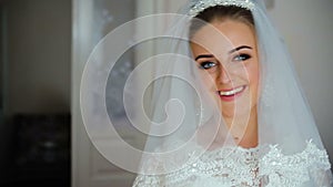 Beautiful bride in white wedding negligee holding and hugging wedding dress