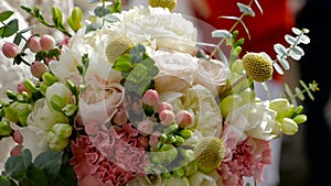 Beautiful brides bouquet in hands of young bride dressed in white wedding dress. Close up of big bunch of fresh white