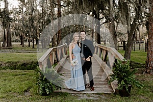 Beautiful Bridesmaid Woman in Blue Dress and Bouquet with Her Date at a Formal Wedding Party Celebration Event Outside in the Wood