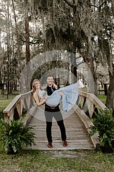 Beautiful Bridesmaid Woman in Blue Dress and Bouquet with Her Date at a Formal Wedding Party Celebration Event Outside in the Wood