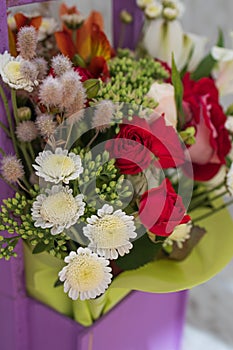 beautiful bright bouquet in a purple basket on a white background, copy space