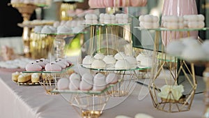 Beautiful bright buffet with many sweet snacks a candy bar on a white table and is waiting for guests at the celebration