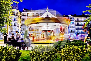 Beautiful bright carousel at night. Amusement park of the city in winter.