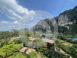 Beautiful bright green palm trees jungle on the mountain hill with holiday hotels and villas in Ao Nang photo