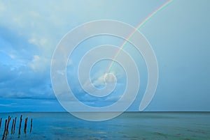 Beautiful, bright, lucent and real rainbow across the ocean photo