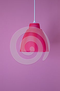 Beautiful bright pink lamp on a pink wall background