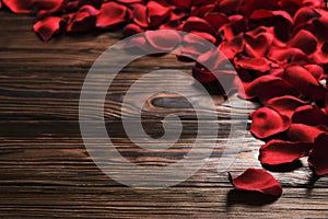 Beautiful bright red rose petals on wooden background. Happy valentines day oliday sales concept.