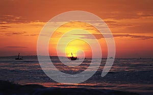 beautiful bright seascape with red dawn , blue sea and silhouette of the fishing boats