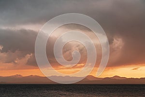 Beautiful bright sunset sky over the mountains silhouette . Dramatic orange clouds after sunset. Nature backgrounds.