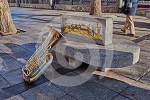 Beautiful and bright tuba resting on a stone bench with ornament in the Plaza de Zocodover, Spain photo
