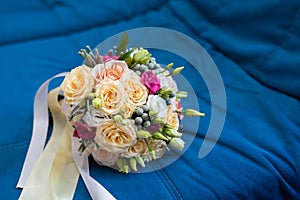 Beautiful bright wedding bouquet with wedding rings on blue background
