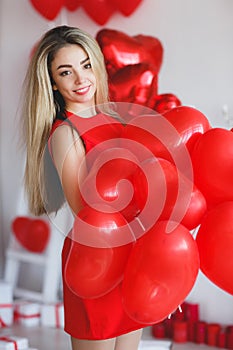 Beautiful bright woman with red balloons on Valentine`s day