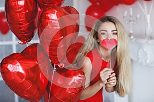 Beautiful bright woman with red balloons on Valentine`s day