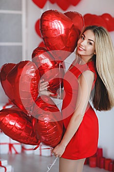 Beautiful bright woman with red balloons on Valentine`s day