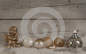 Beautiful bronze and golden glass christmas baubles and candle and angel, on sheepskin