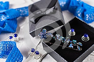 Beautiful brooch with blue and aquamarine stones and rhinestones of different sizes, metal base pins in a gift box with a black bo