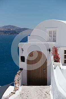 Beautiful brown door on white facade of greek architecture hotel in Oia city, Santorini island, Greece, Europe.