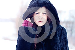 Beautiful brown-eyed brunette girl winter black coat posing background trees, fashion style concept idea, portrait