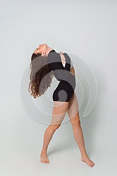 beautiful brown-haired woman in black bodysuit on white background in the studio. Caucasian dancehall dancer