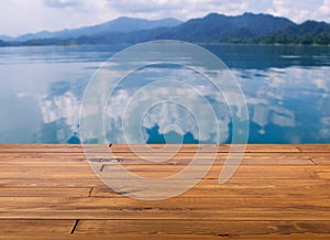 Beautiful brown plank wooden table or floor, little shiny surface, perspective view, the background of blurred mountainscape and