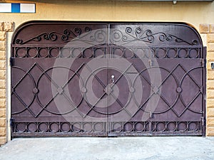 Beautiful brown winches with forging elements on the background of the facade