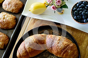 Beautiful brunch flat lay of home baked croissants and healthy fresh blueberry and lemon citrus fruit