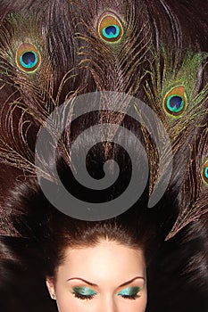 Beautiful brunet long hair decorated with peacock