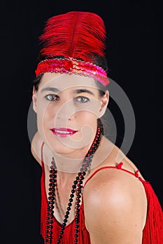 beautiful brunette in 1920 style attire red dress and a fe