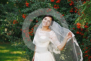 Beautiful brunette bride with bouquet outdoor. Happy bride outdo