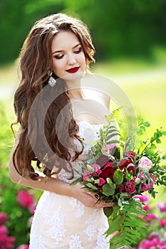 Beautiful brunette bride outdoor portrait. Woman with wedding bo