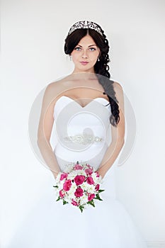 Beautiful brunette bride in a wedding dress and a crown on her head.