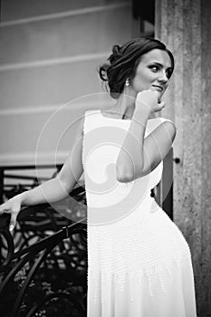 Beautiful brunette bride in white dress walking up stairs