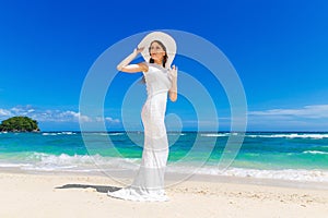 Beautiful brunette bride in white wedding dress and straw hat ha