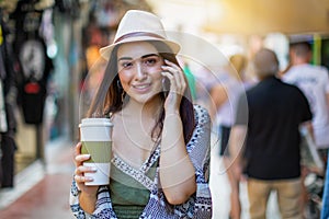 Beautiful, brunette, city girl talking to a mobile phone in the street