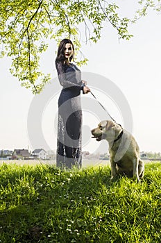 Beautiful brunette in a dress with doggy on stairs, crosswalk. Grirl with dog