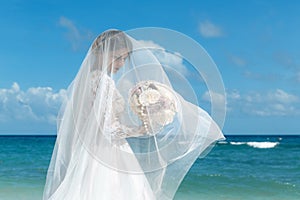 Beautiful brunette fiancee in white wedding dress with big long