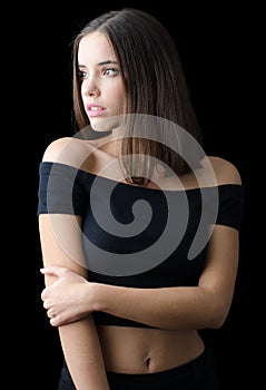 Beautiful brunette girl in black clothes isolated on black