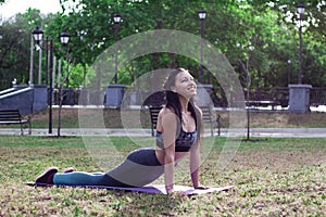 Beautiful   brunette girl is  doing yoga Cobra Pose Bhujangasana.  Concept of sport