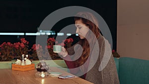 Beautiful brunette girl drinking coffee or tea in cafe with copy space