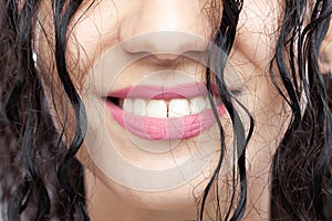 Beautiful brunette girl with long wet hair, abstract closeup studio portrait. Smiling face expression. Big smile with white teeth