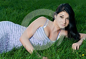 Beautiful brunette girl lying in grass.