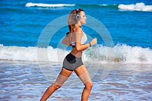 Beautiful brunette girl running in a summer beach