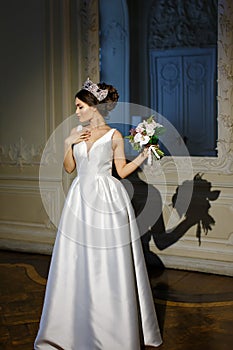 Beautiful brunette girl in white dress and with a brilliant crow