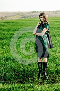 Beautiful brunette girl in windy green field, sunny springtime,