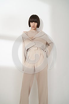 Beautiful brunette with graphic bob haircut wear beige fashion pantsuit