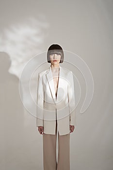 Beautiful brunette with graphic bob haircut wear beige fashion pantsuit photo