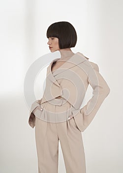 Beautiful brunette with graphic bob haircut wear beige fashion pantsuit photo