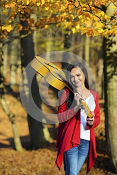 Beautiful brunette guitar player girl in the forest